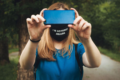 Midsection of woman photographing with mobile phone