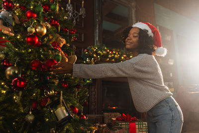 Portrait of young woman decorating christmas tree