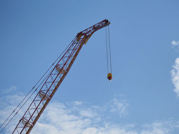 Low angle view of crane against sky