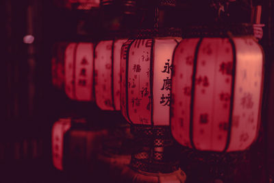 Close-up of five paper lanterns in a row with non-western script on it