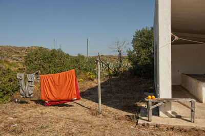 Clothes drying on field against clear sky