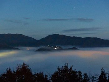 Scenic view of lake and mountains against sky at dusk