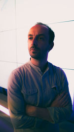 Portrait of young man standing against wall