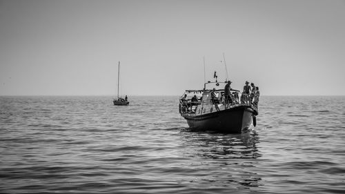 Sailboat sailing in sea against clear sky