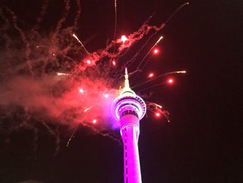 Low angle view of illuminated tower against sky at night