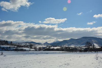 Snow covered land and mountains against sky