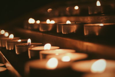 Close-up of illuminated tea light candles on altar