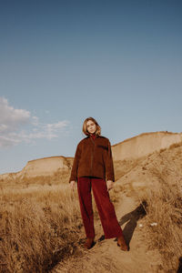 Portrait of woman standing on land against sky