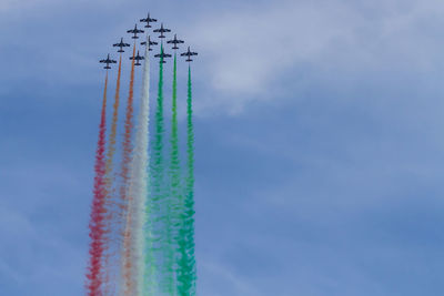 Low angle view of airplanes flying against sky during airshow