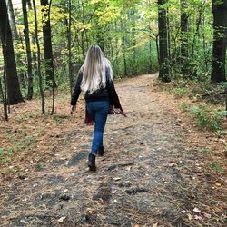 Rear view of woman walking in forest