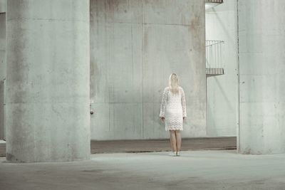 Rear view of woman standing against wall