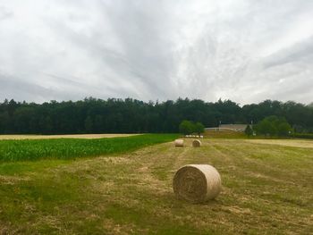 Hay bales on field against sky