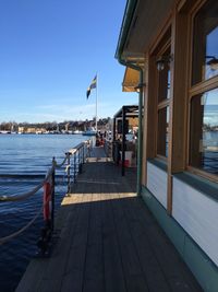 People at coffee shop by swedish flag on lake