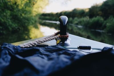 Close-up of rope tied to bollard in boat on lake