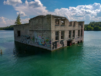 Built structure by sea against sky