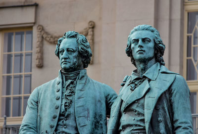 Low angle view of statue against historic building