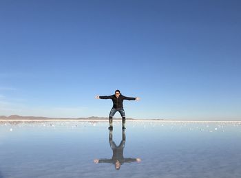 Full length of person standing in water against sky