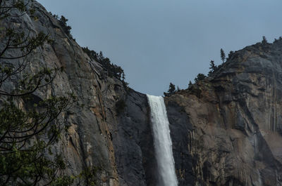 Low angle view of waterfall against sky