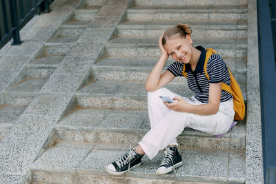 Side view of woman sitting on steps