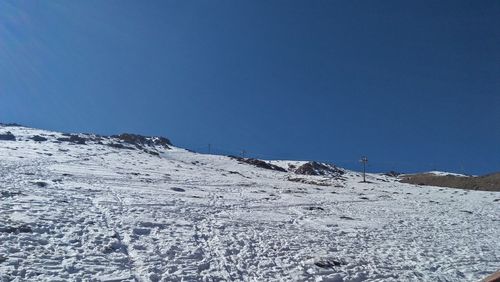 Scenic view of snowcapped mountains against clear blue sky