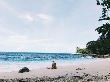 People at beach against sky