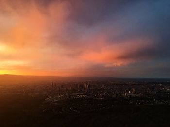 Aerial view of city against cloudy sky during sunset