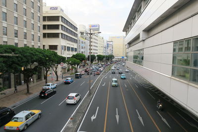 Traffic on road amidst buildings in city