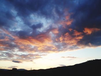 Low angle view of silhouette mountain against dramatic sky