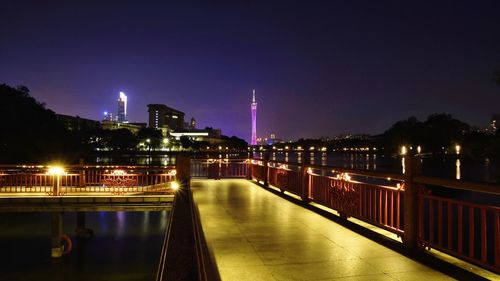 Illuminated bridge over river at night