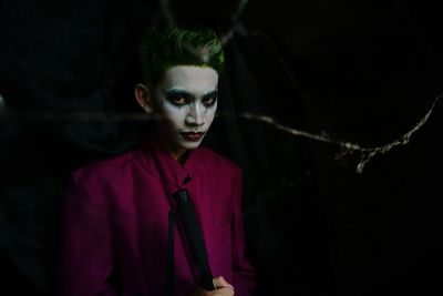 Portrait of man with spooky make-up in darkroom