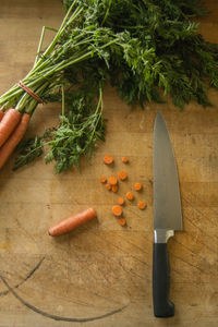 High angle view of carrots and knife on cutting board