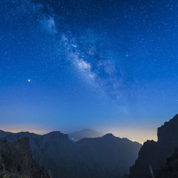 Scenic view of mountains against sky at night