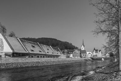 Scenic view of river by building against clear sky