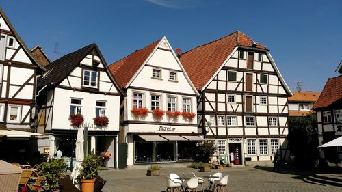 Houses by street against sky in city