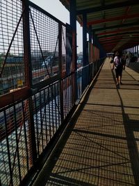 Rear view of people walking on footbridge