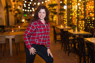 Portrait of smiling young woman standing on table