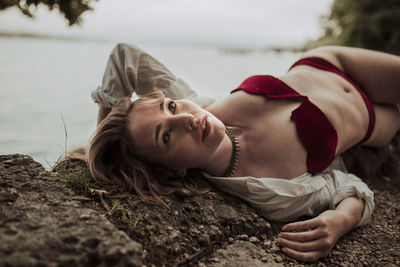 Portrait of woman lying next to a lake