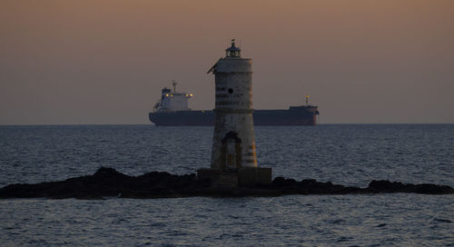 The lighthouse of the mangiabarche of calasetta with the sunset lights