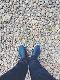 Low section of person standing on pebbles