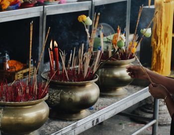 Close-up of hand in container outside temple