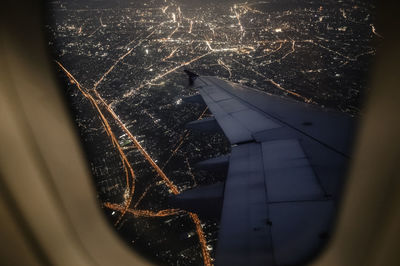 Illuminated cityscape seen through airplane window