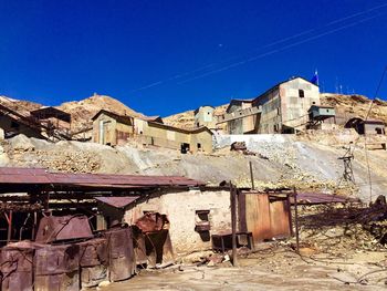 Abandoned houses against clear blue sky