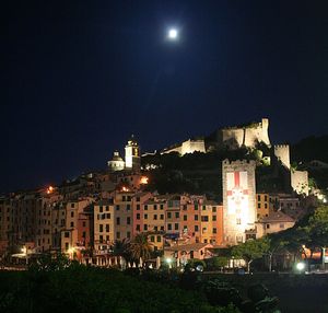 Illuminated cityscape against sky at night