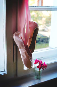 Ballet shoe and flowers at window