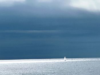 Sailboat sailing on sea against sky