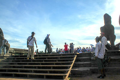 People on staircase against sky