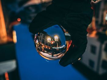 Close-up of hand holding illuminated glass