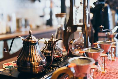 Close-up of teapots with coffee makers on table