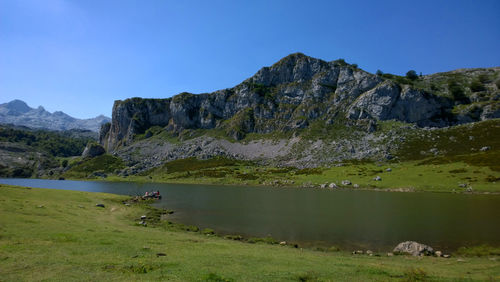 Scenic view of lake and mountains against blue sky