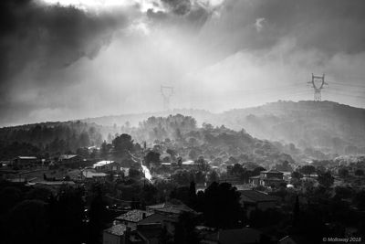 Aerial view of townscape by mountain against sky